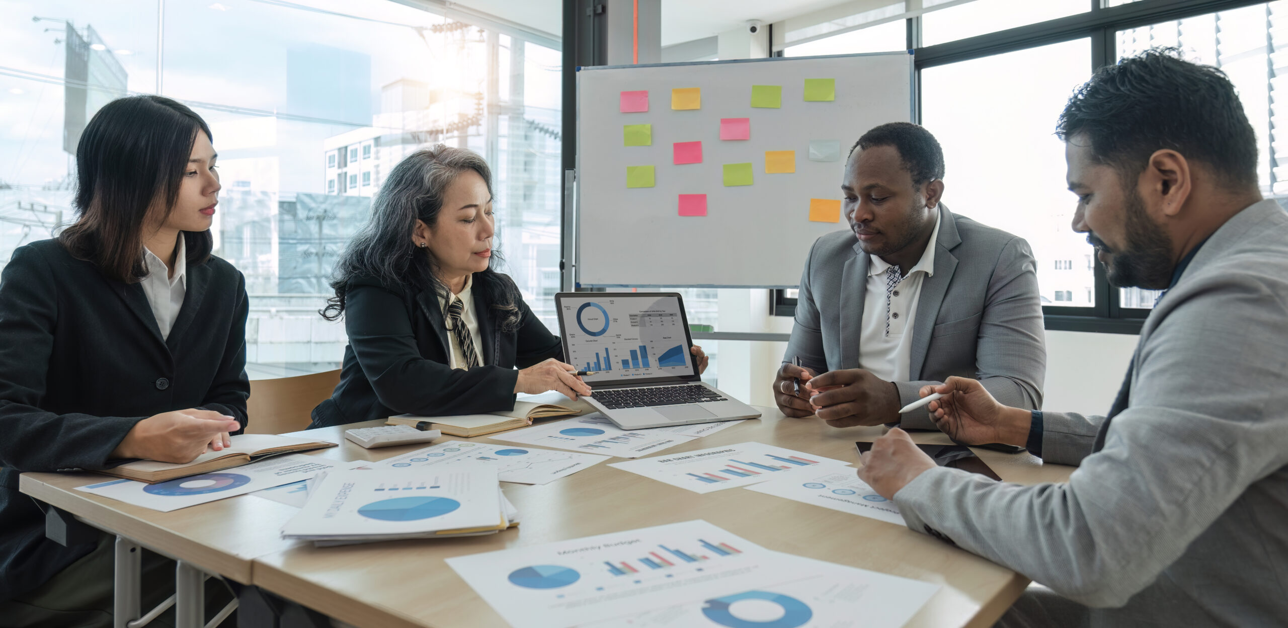 Business People Meeting using laptop computer,calculator,notebook,stock market chart paper for analysis Plans to improve quality next month. Conference Discussion Corporate Concept..